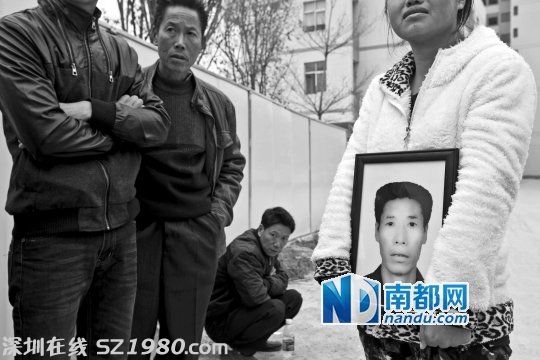 在新塘派出所門口，女兒拿著父親劉先生的遺像為其討公道。 南都記者 黎湛均 攝