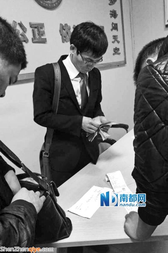 <p> 3月13日，與梁先生的撞車事故調(diào)解獲得賠償后，徐某在大浪交警中隊調(diào)解室數(shù)錢。</p><p> 南都記者 陳文才翻拍</p>