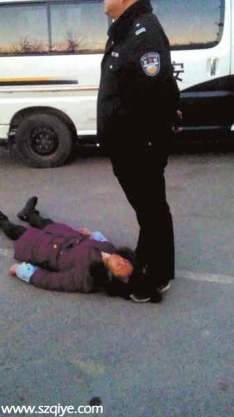 事發(fā)現(xiàn)場(chǎng)一名身穿警服的男子疑似用腳踩著女農(nóng)民 工周秀云的頭發(fā)（12月13日攝）。