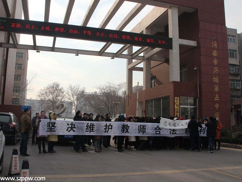 13日上午，濟南市歷城第五中學(xué)校門口，該校老師打起橫幅維權(quán)。（攝影 宋翠）